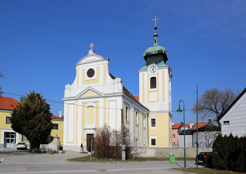 Südansicht der röm.-kath. Pfarrkirche hl. Markus in der niederösterreichischen Marktgemeinde Leopoldsdorf im Marchfeld, die sich bis 2021 Leopoldsdorf im Marchfelde nannte. Der barocke Sakralbau wurde von 1771 bis 1774 errichtet, wobei vermutlich der Turm des Vorgängerbaues bis zum Glockengeschoß in den Neubau integriert wurde.