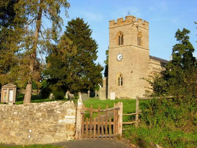 Churchyard and west tower of the parish church of St John the Baptist, Tiffield, Northamptonshire, seen from the southwest