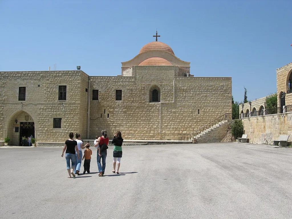 Visitors walk the premises of Saint George Monastery. Saint George Monastery or Deir Mar Georges is a historic Greek Orthodox monastery in the village of al-Mishtaya in the "Valley of the Christians" (Wadi al-Nasara) in northwestern Syria. The valley is a regional center of Christianity since the 6th century. Al-Mishtaya, Homs, Syria.