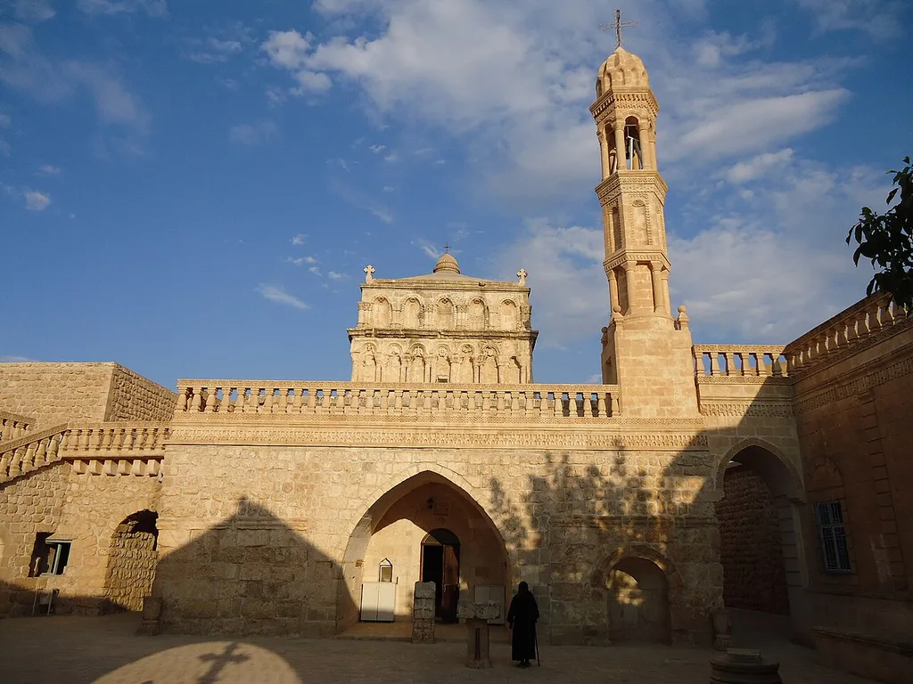 On a website (https://mardin.ktb.gov.tr/TR-311718/anitli-meryem-ana-kilisesi.html ) one can read "The church, unique from an architectural point of view, is located in the southern part of Anıtlı Village. The temple named as Yoldath Aloho (Mother of God); often referred to as Al Harda (virgin) in Arabic. The construction date of the church associated with the birth of Jesus. It is thought that the structure was initially built as triumphal arch-shaped Roman structure in the 1st century, later converted to church between 5th and 6th centuries. The external superstructure of the dome and the bell tower are 20th century additions. The church resembles the Deyrulzeferan monastery with its square plan and central dome, which is rare in Mardin."