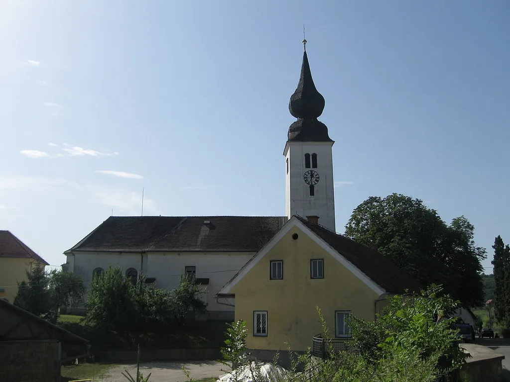 Cerkev je prvič omenjena v 14. stol., po porušitvi 1532 je bila 1567 znova pozidana. Sestavljajo jo zvonik, ladja, prezbiterij in baročna zakristija. Notranjščina je baročno obokana, oprema je baročna. V južni steni sta vzidana rimskodobna kamna.