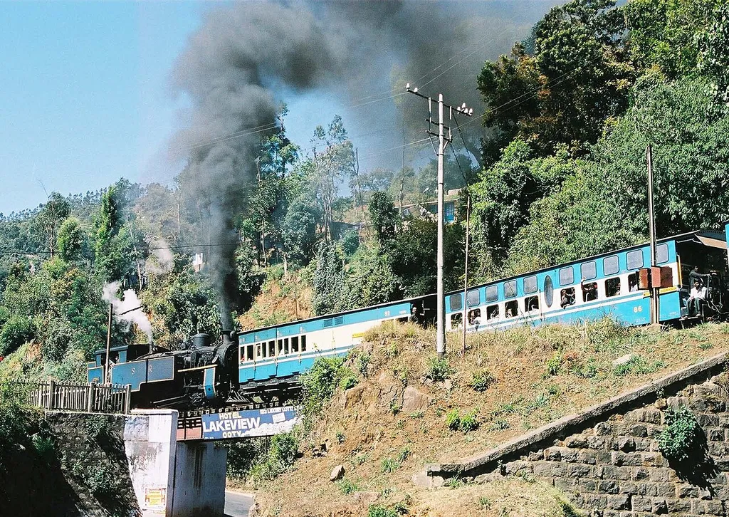 Nilgiri Mountain Railway train climbs past Kateri Road. The locomotive is No.37392. 28th February 2005 AUTHOR : SELVA KUMAR.L - DHARMAPURI Camera - Minolta X700 (35mm film) Modified - Scanned by film developer. File size and definition changed using Adobe Photoshop 5.0LE