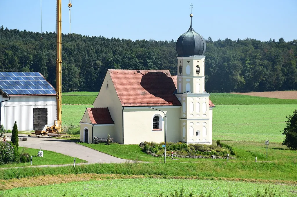 Saalkirche mit Steildach, polygonaler Chor, viergeschossiger Turm mit Putzgliederung