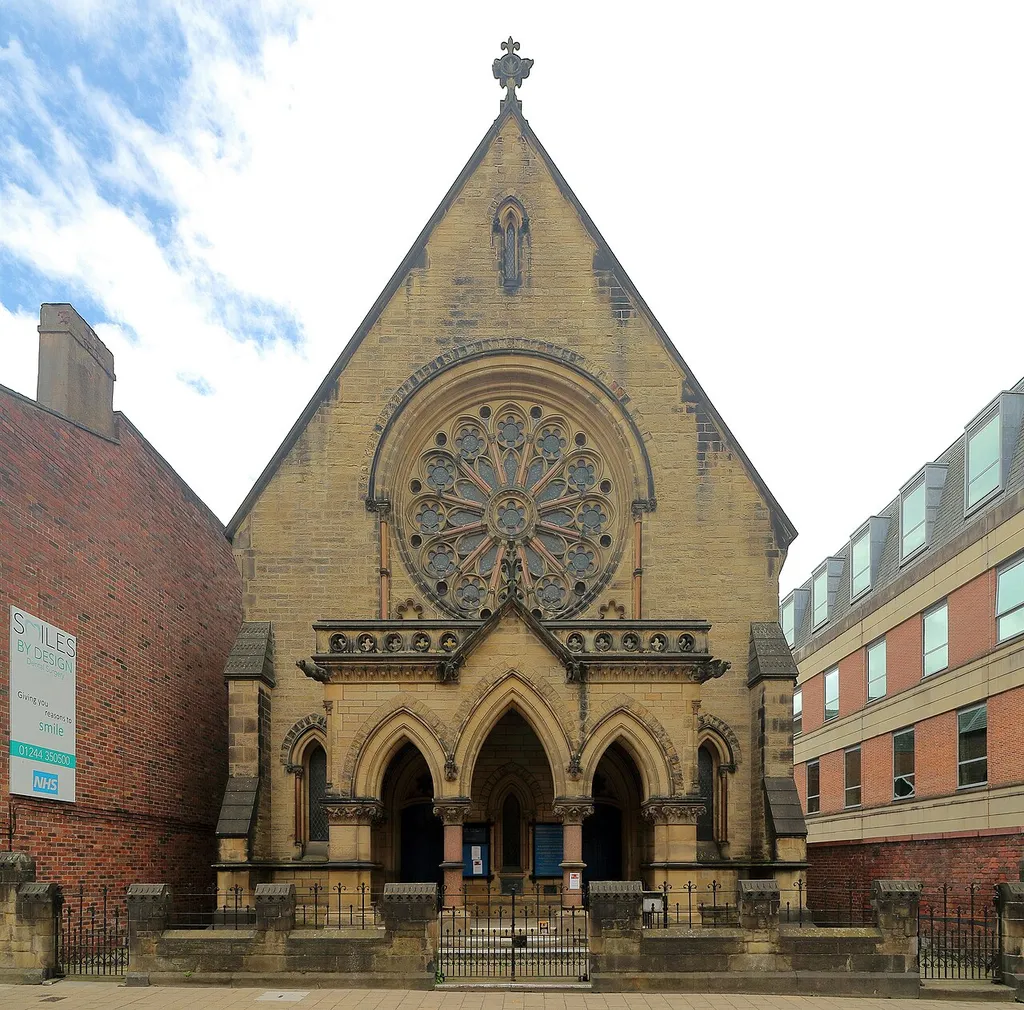 Grade II listed church, 1866, by W. &amp; G. Audsley with a sandstone frontage and the sides and back in brick. The wall and railings to the front are included in the listing.