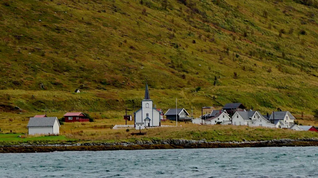 Helgøy church was used by the small remote island community of Helgøy, which is only accessible by boat. The church building itself was first built in Helgeland in 1741, then moved north to Senja in 1872, and finally moved to serve the community of Helgøy in 1888. This was part of a practice of reusing consecrated buildings to serve isolated communities. Helgøy's homes are now used as holiday cabins, and the church is used once a year during the summer solstice.