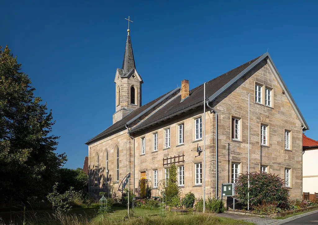 Evang.-Luth. Christuskirche in Jesserndorf, neugotischer Saalbau aus Sandsteinquadern mit Satteldach und Fassadenturm mit Pyramidendach; angebaut zweigeschossiges und zur Straße giebelständiges Pfarrhaus, Sandsteinquaderbau mit Satteldach, 1857/58