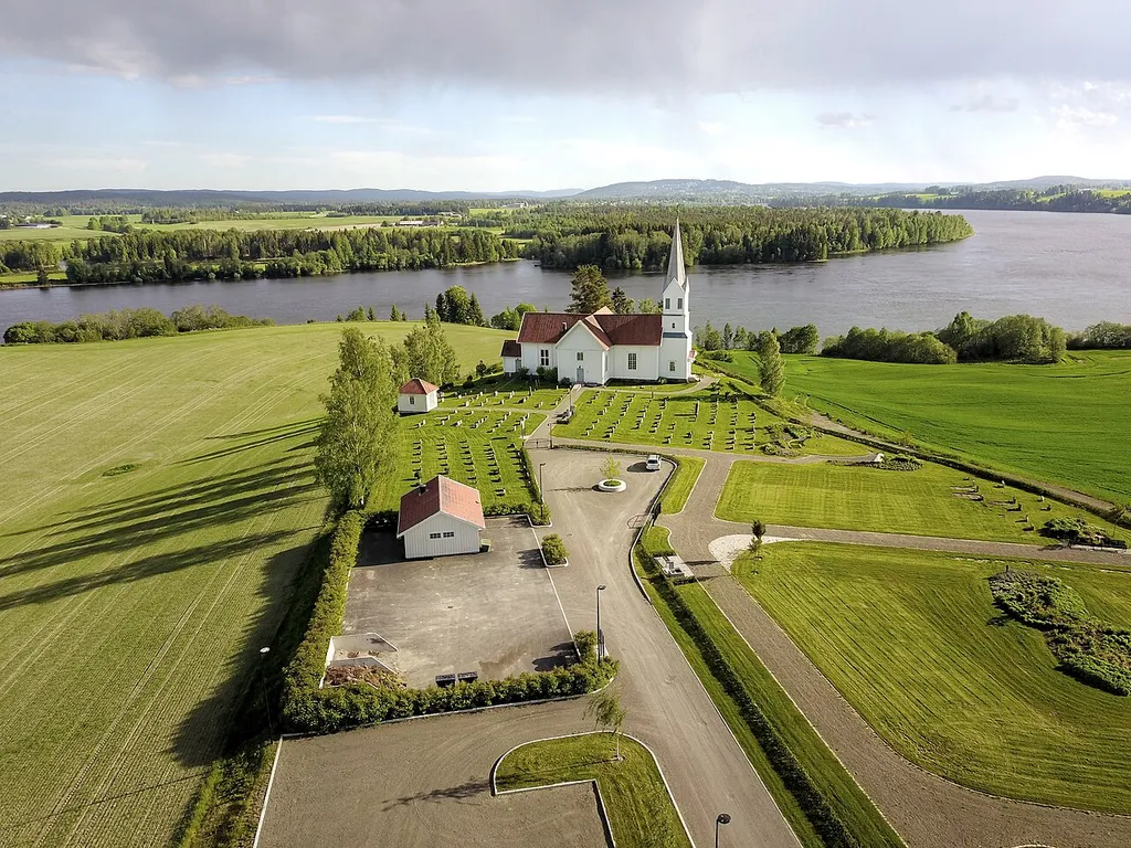 Udnes church in Nes municipality, Akershus, Norway with Glomma river in the background