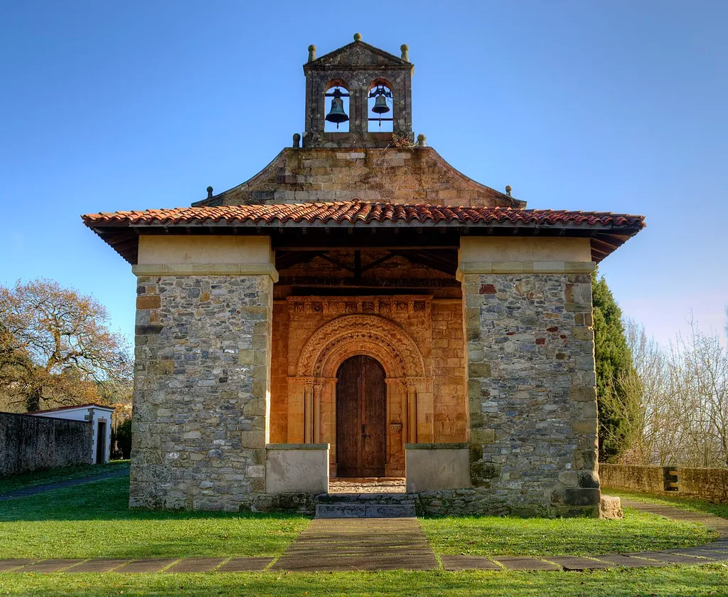 Iglesia de finales del siglo XII que conserva una portada hoy protegida y en buen estado de conservación. La luz reflejada en la parte interior del pórtico iluminó la portada debido a la hora en la que tomé las fotos. Está en Narzana, concejo de Sariego, Asturias.