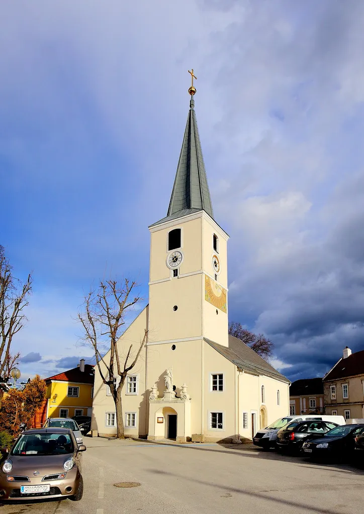 Südwestansicht der katholischen Filialkirche hl. Nikolaus in der niederösterreichischen Stadt Traiskirchen.Eine am Hauptplatz freistehende Kirche, dessen Kernbausubstanz romanisch ist. Der Westturm mit steilem Pyramidendach wurde 1859 errichtet.