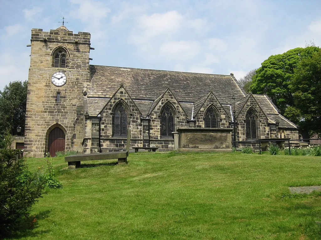 St Peter's Church, Town Street, Rawdon, West Yorkshire. View from the South. It is high above Town Street on steeply sloping ground (the burial ground). Grade II listed. Clock tower is sandstone, dated 1706. Slate roof.