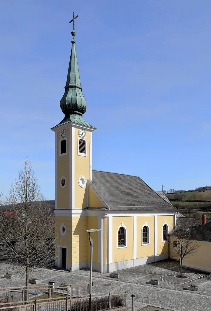 Westansicht der röm.-kath. Pfarrkirche hl. Johannes Nepomuk in Unterbergern, ein Ortsteil der niederösterreichischen Gemeinde Bergern im Dunkelsteinerwald.Eine schlichte josephinische Saalkirche in der Ortsmitte, die 1766 als Kapelle errichtet und nach der Pfarrerhebung von 1784 bis 1785 durch Johann Schwerdtfeger vergrößert wurde. 1868 wurde der Turm um ein Schallgeschoß erhöht und erhielt den heutigen Turmhelm.