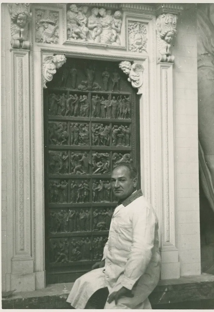 Portrait of the Italian sculptor Giannino Castiglioni in front of the second door from the left of the Milan Cathedral, Life of Saint Ambrose, created by the artist and inaugurated in 1950.