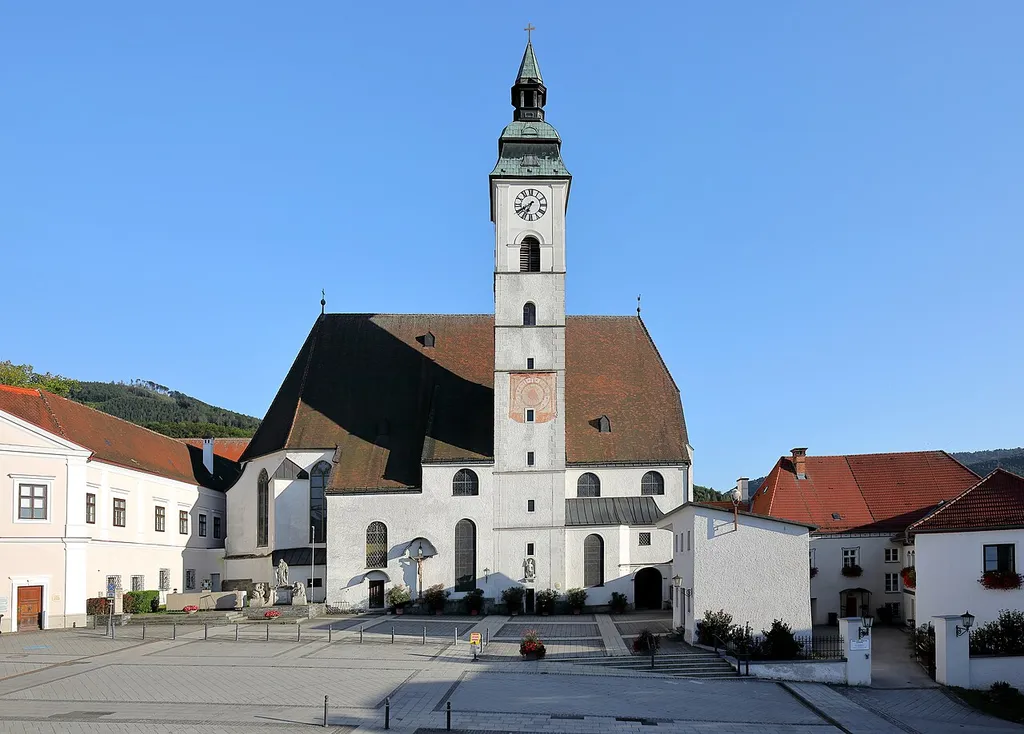 Nordansicht der röm.-kath. Pfarrkirche hl. Maria Magdalena der niederösterreichischen Stadtgemeinde Scheibbs.Eine Hallenkirche in erhöhter Lage an der Südfront des Rathausplatzes, die Anfang des 16. Jahrhundert unter Einbeziehung des Kirchturms der Vorgängerkirche errichtetet wurde. 1609 und 1839 erfolgte eine Turmerhöhung. 1627 bis 1637 sowie nach einem Brand 1645 erfolgten An- und Umbauarbeiten statt und eine sukzessive Barocksierung statt.
