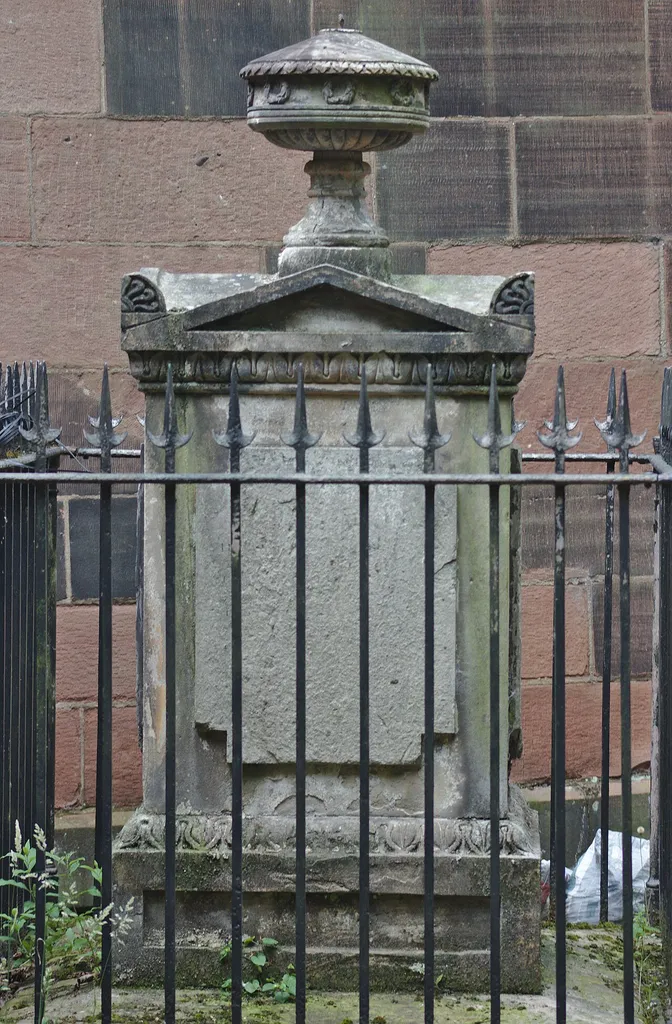 Grade II listed monument in the churchyard of St Michael, Huyton. Set with railings, it is inside a fenced-off area and not possible to examine closely; in any event, the dedicatee is not known.