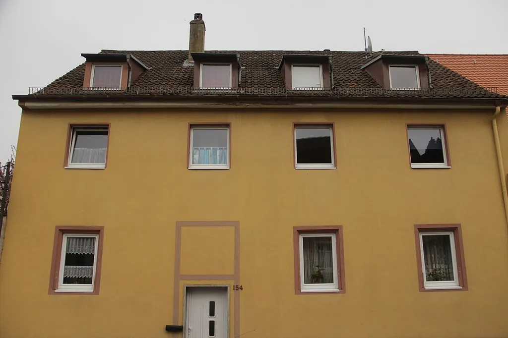 ein- bzw. zweigeschossige Massivbauten mit Satteldach und Sockelgeschoss, Nr. 50 noch mit gestelzten Fensterprofilen, im Kern Anfang 17. Jahrhundert, nach der Säkularisation stark verändert, 19. Jahrhundert