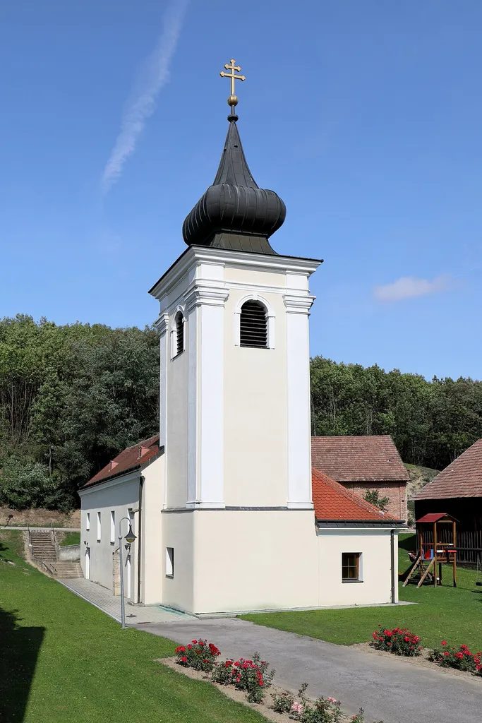 Südostansicht der röm.-kath. Filialkirche hl. Antonius der Einsiedler in Oberschoderlee, ein Ortsteil der niederösterreichischen Marktgemeinde Stronsdorf. Ein schlichter rechteckiger Saalbau aus dem 17. Jahrhundert mit wuchtigem Ostturm, die später umgebaut wurde.