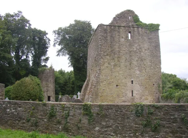 Aghaviller ruined church and round tower, Newmarket, Co. Kilkenny. The church is monastic of the 12C (dedicated to St Brenainn), with a 15C tower built over the chancel. The round tower has had a door inserted at ground level.