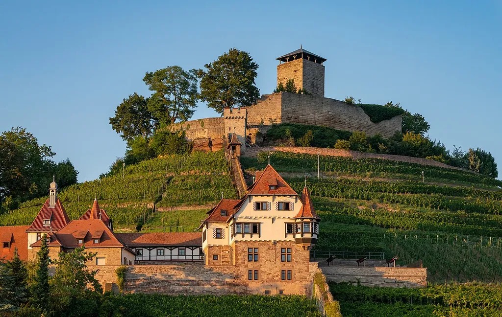 Beilstein, Württemberg, Germany: View from the Birkenweg to Hohenbeilstein Castle (on the top of the hill) and to the so-called Unteres Schloss, a listed villa built from 1906 to 1908 in historicist style. The photo has been taken in the evening sun, this explains the warm colours.