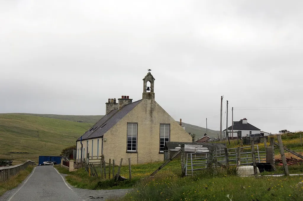 Category C Listed 1878 Mission Chapel and Manse. Its double cottage design is unusual in Shetland and more in keeping with school and schoolhouse arrangements on the mainland. It was reported in July 2014 that the church will receive £7,100 from the Heritage Lottery Fund to replace its windows, and help provide better facilities to make the church more suitable for wider community use.