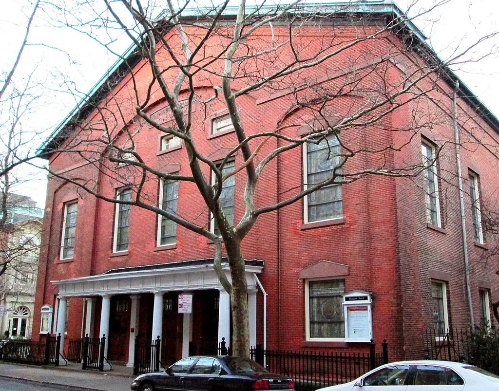 The Plymouth Church on Orange Street between Henry and Hicks Street in the Brooklyn Heights neighborhood of Brooklyn, New York was built in 1849-1850 and was designed by Joseph C. Wells. It has Tiffany stained glass windows that came from the Congregational Church of the Pilgrims when the two parishes merged in 1934. The church is notable for being the home church of Henry Ward Beecher from 1847 to 1887, where he preached his abolitionist views. The church complex, which includes a Parish House and connecting arcades (1913-1914, by Woodruff Leeming), is located within the Brooklyn Heights Historic District, and the church is a National Historic Landmark. (Source: AIA Guide to NYC (5th ed.))