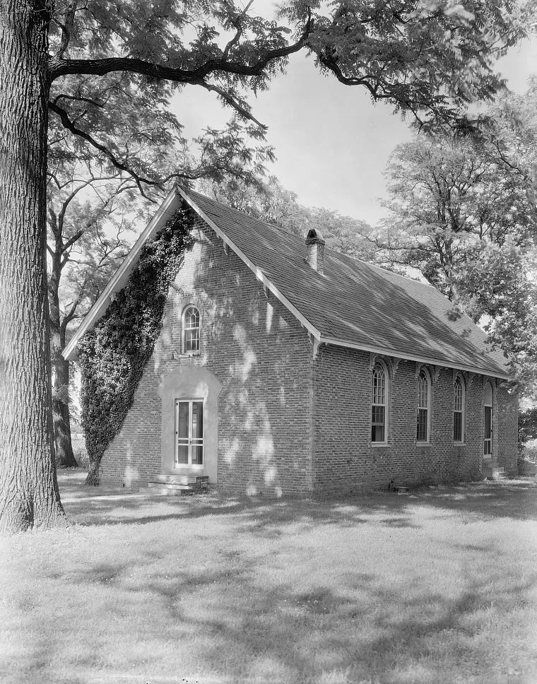Black-and-white photographic view of the exterior of Westover Church, Charles City Courthouse vicinity, Charles City County, Virginia, by the American photographer and photojournalist Frances Benjamin Johnston. Dated 1930. The church was used in the early 19th century as a barn, and was later used as a stable by Union forces during the Civil War. The church was restored in the interim by members of the Berkeley and Shirley families, some of whom are buried within the churchyard. In 1867, the church was again used for worship, and was restored again in 1909. Photograph forms part of the Frances Benjamin Johnston archives at the Library of Congress, which were donated in perpetuity to the Library by the photographer, hence there are no restrictions on publication. Image courtesy of the Library of Congress, Prints and Photographs Division, Washington, D.C.