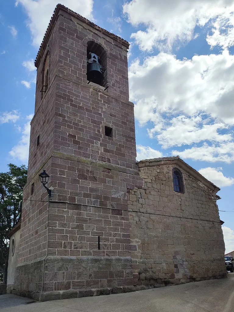Torre con campana a la vista a la izquierda, y lado oeste de la iglesia de San Millán de Oco