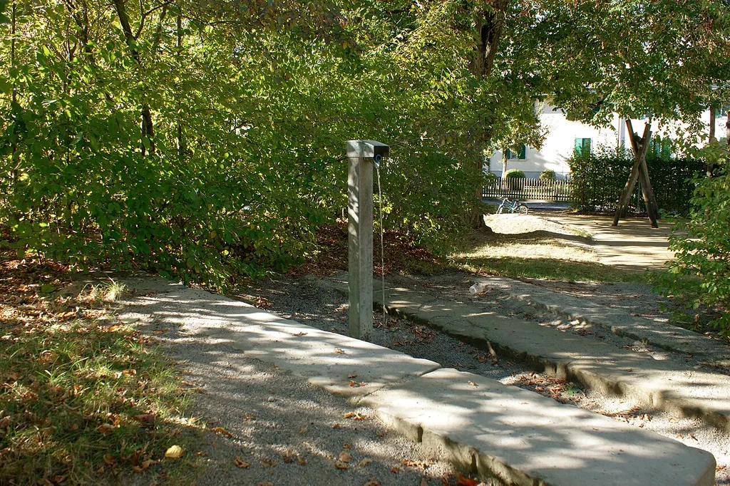 Spielbrunnen Spielplatz Brünnackerstrasse mit Gebäude Gebäude Bottigensrasse 51-52 im Hintergrund.