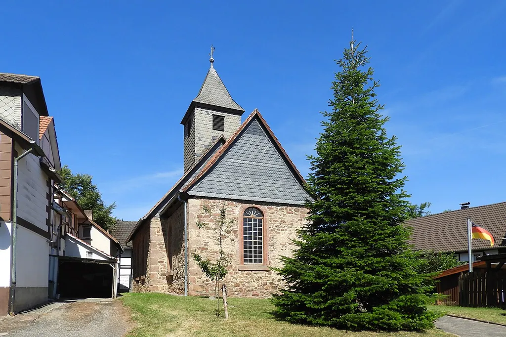 Die evangelische Kirche aus dem Jahr 1797 besitzt einen mittelalterlichen Kern in massivem Mauerwerk, mit steinsichtig verputzten Bruchsteinen. Auf dem Langhaus sitzt ein verschieferter Dachreiter auf, mit einer Wetterfahne, die die Jahreszahlen 1797 und 1992 trägt. Jenseits davon ist der rechteckige Chor deutlich abgesetzt. Der schlichte Innenraum wird von einer Flachdecke geschlossen, an der Nord- und Westwand erstreckt sich eine Empore mit kassettierter Brüstung. Als bemerkenswert angesehen wird die Holzkanzel mit ihrem reichem Beschlagwerk, die in das Jahr 1668 datiert wird, sowie die Orgel mit barockem Prospekt, die, so wird vermutet, von J. W. Schmerbach d. Ä. erbaut wurde. Wegen ihrer künstlerischen, geschichtlichen und baulichen Bedeutung ist die Kirche ein geschütztes Kulturdenkmal.