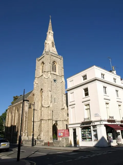 Church of St Michael, Chester Square, near to Chelsea, Kensington And Chelsea, Great Britain. The church dates from 1846. "Decorated style. Broad multi-gabled form with north tower of 2 stages with recessed broach spire" <a title="https://historicengland.org.uk/listing/the-list/list-entry/1357286" rel="nofollow" href="https://historicengland.org.uk/listing/the-list/list-entry/1357286">Link</a><img style="padding-left:2px;" alt="External link" title="External link - shift click to open in new window" src="http://s0.geograph.org.uk/img/external.png" width="10" height="10"/> . Seen across the junction of Chester Row and Elizabeth Street. The building on the right at no 58, Elizabeth Street is part of a group dating from 1830 listed "for group value only" <a title="https://historicengland.org.uk/listing/the-list/list-entry/1066840" rel="nofollow" href="https://historicengland.org.uk/listing/the-list/list-entry/1066840">Link</a><img style="padding-left:2px;" alt="External link" title="External link - shift click to open in new window" src="http://s0.geograph.org.uk/img/external.png" width="10" height="10"/> . That's damning with faint praise.
