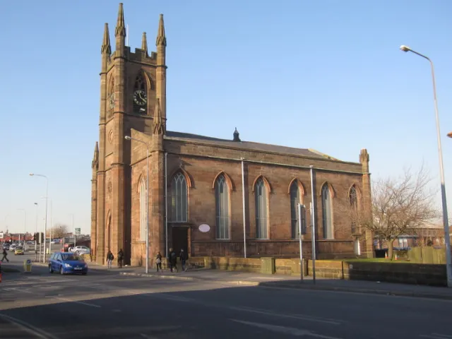 St James's Church, Latchford. Looking across Wilderspool Causeway towards the church of St James. There is a bench mark on the pillar this side of the west door 1743802