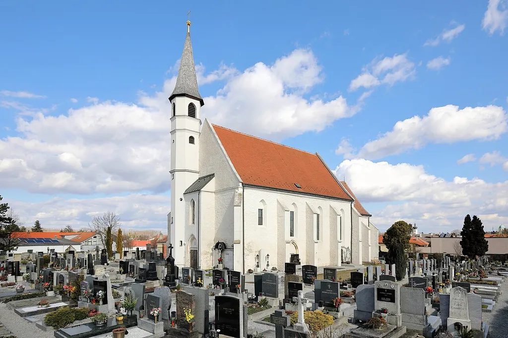 Südwestansicht der röm.-kath. Filialkirche hl. Quirinus in der niederösterreichischen Stadtgemeinde Fischamend.Die Kirche der ehemaligen Gemeinde Fischamend-Dorf ist von einem Friedhof und Mauer umgeben. Die gotische Saalkirche mit einem eingezogenen Chor wurde im 14. Jahrhundert errichtet und ab 1671 umgebaut sowie barockisiert.