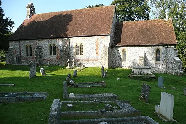St. Mary the Virgin church, Vernhams Dean, near to Vernham Street, Hampshire, Great Britain. The parish is called Vernhams Dean, the village is Vernham Dean. The church is a mile from the current village centre, closer to the hamlet of Vernham Street. The church is on a sloping site, down to the east. It has an ornate Norman west door, but is otherwise Victorian, about 1851. This is the south side across a churchyard full of interest.