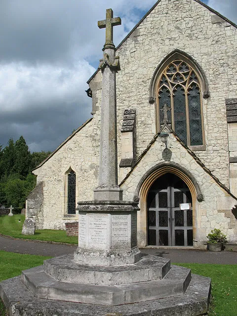 War memorial in St Michael's parish churchyard, Betchworth, Surrey, with the west end of the parish church behind