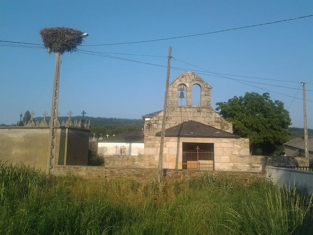 Igrexa parroquial de Santa María de Lama no concello lugués de Láncara. Á esquerda da imaxe obsérvase un niño de cegoña branca.