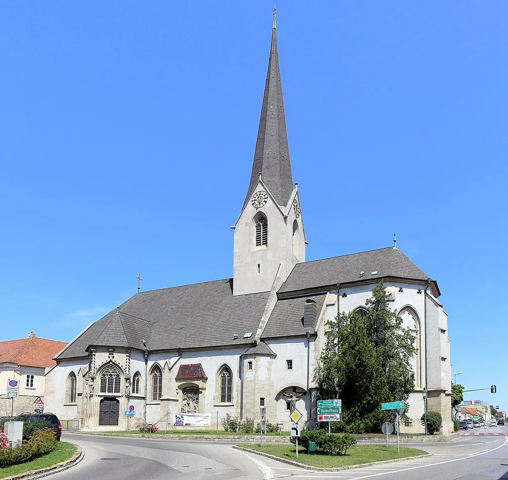 Südostansicht der röm.-kath. Pfarrkirche hl. Kunigunde in der niederösterreichischen Marktgemeinde Brunn am Gebirge.Die gotische Kirche wurde über einer spätromanischen Chorquadratkirche in mehreren Bauphasen ab der ersten Hälfte des 14. Jahrhunderts errichtet. 1855/56 erfolgte eine Renovierung und ein Umbau sowie ein Neubau des Turmes. Eine weitere Renovierung und Umgestaltung führte Gustav von Neumann in den Jahren 1897 bis 1900 durch.
