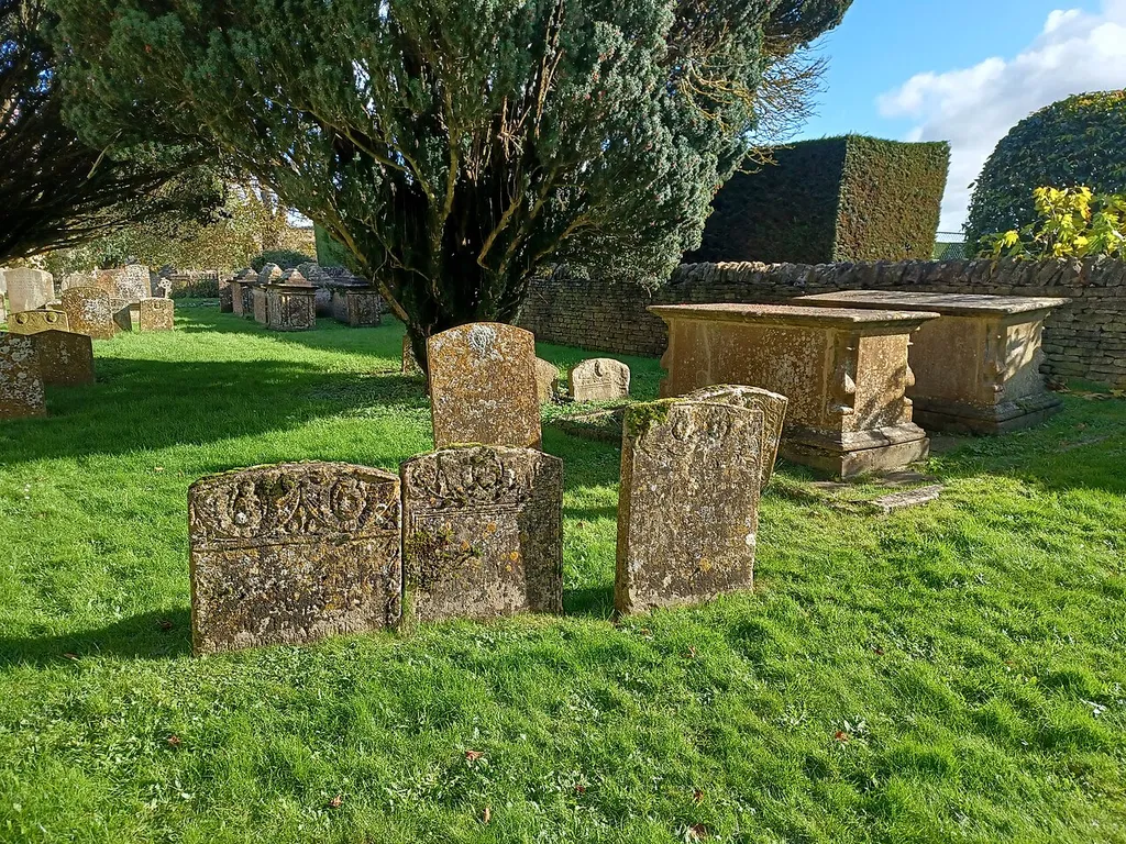 Chest tombs south of St. Nicholas' Church, Chadlington, Oxfordshire, England. The two tombs against the churchyard wall are late 18th century, Grade II listed.