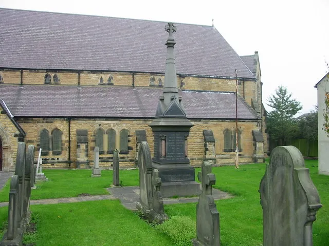 Part of St Michael and All Angels parish church, Easington Lane, Tyne and Wear, seen from the southwest. The monument in the foreground commemorates the 1886 Elemore Colliery disaster.