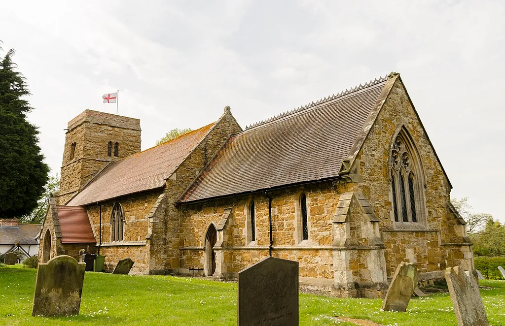 (The church was formerly known as Saint Nicholas) Although North Kelsey is mentioned in the Domesday survey, there is no record of the church in 1086. It dates from the 13th century, and was extensively rebuilt apart from the tower, in 1784 and 1860. It is thought that stone from the demolished South Kelsey church was used in the renovations. There is a western tower, nave with north aisle, chancel, vestry, and south porch. The tower contains some 13th century windows and an 18th-century doorway. There are three bells. The four-bay north aisle was a gift to the church by John Wyga in 1372. This was rebuilt by William White in the 19th C. incorporating pink marble piers. There is a slab in the chancel with a foliated cross probably from the mid-13th century. At the west end of the south wall of the nave on the outside of the church is a slab with zigzag patterning, probably a grave slab. There is a stained-glass window depicting a Victorian Jesse tree at the east end of the north aisle. The church has a small organ, maker unknown.