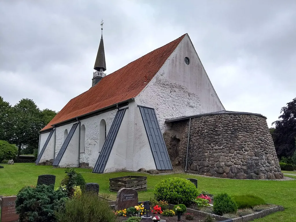 Blick von NW auf die St.-Andreas-Kirche in Weddingstedt mit dem Sumpf des in der Letzten Fehde 1559 zerstörten Rundturms