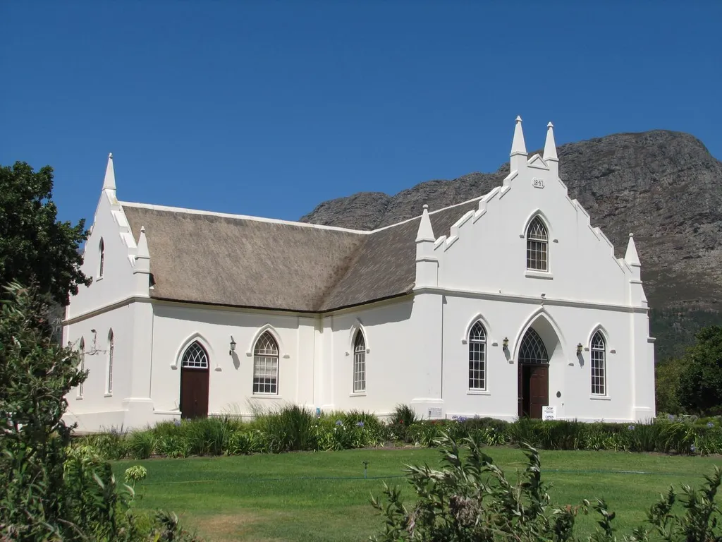 Built in 1847 and situated on the main road running through the town. This valley tightly hemmed in by mountains, is named after the French Huguenots who fled to the Cape after religious persecution in 1688. They brought with them a sound knowledge of viniculture and settled down to make wine in the ?French Glen? where the estates and many families still have French names. There is just one main street lined with wine estates and a few antique shops, cafes and restaurants until at the end you find the impressive Huguenot Memorial and Museum set in rose gardens by a peaceful lily pond. Published at www.tripwolf.com/en/galleries/media/ext/315637/14040/3.