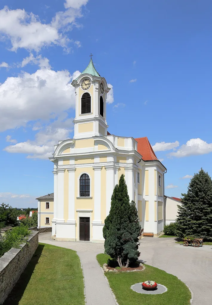Südwestansicht der röm.-kath. Pfarrkirche Zur Unbefleckten Empfängnis der burgenländischen Gemeinde Wimpassing an der Leitha. Der einheitliche Barockbau mit kreuzförmigen Grundriß wurde anstelle einer 1683 zerstörten Kirche errichtet und 1723 geweiht.