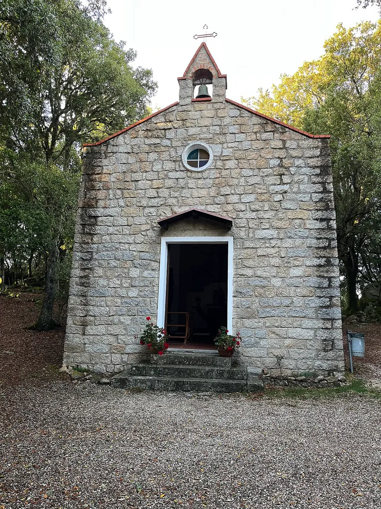 Facciata principale della chiesa con campanile e finestra rotonda.
