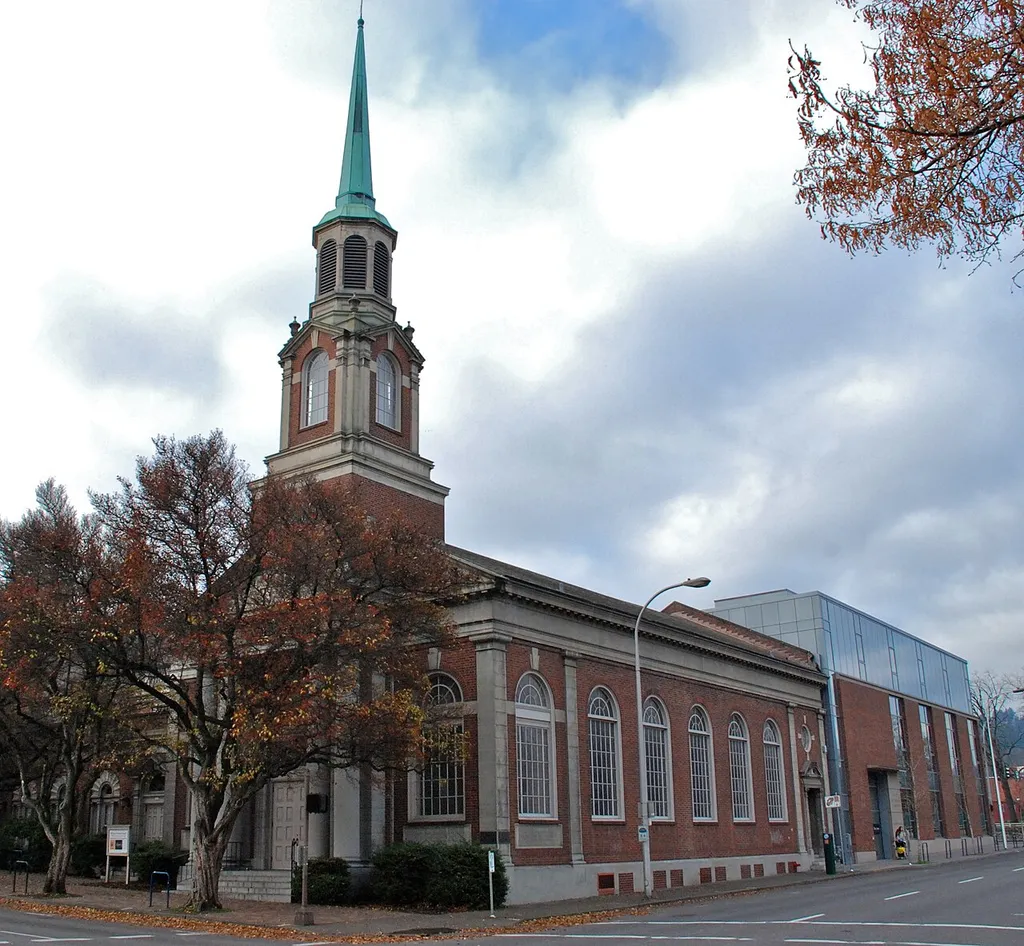 The First Unitarian Church of Portland's 1924 Colonial-style building, at SW 12th &amp; Salmon in downtown Portland, is listed on the U.S. National Register of Historic Places, but nowadays is known as Eliot Chapel by church members, after having ceased to be used as the congregation's main sanctuary in 1979. At that time, the church purchased an adjacent building to the south (not visible here) and began using it for their regular Sunday services. Visible behind the 1924 building in this photo is a 20,000-square-foot new building known as the Buchan Building, which was constructed for the Unitarian Church in 2007. This is an image of a place or building that is listed on the National Register of Historic Places in the United States of America. Its reference number is 78002315 (Wikidata).