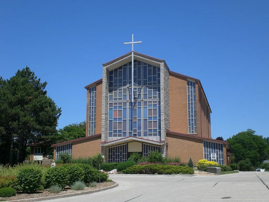 Church front entrance with statue of St. Mary in the traffic island to the left foreground of the picture.