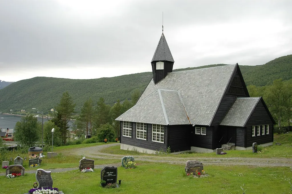 Komagfjord Church is a wooden cruciform church, which was completed in 1960. It has a capacity for 250 people, and is located on a small hill overlooking the Komagfjord.